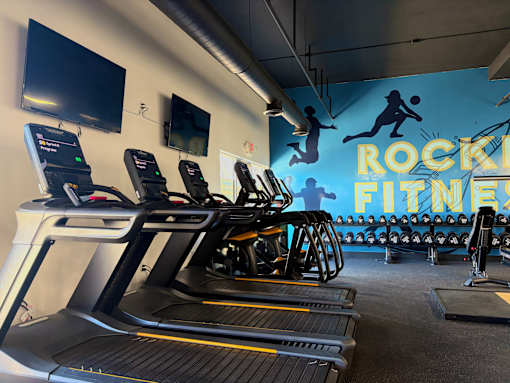 A gym with treadmills and a sign that says Rock Fitness. at Vivo Toledo Apartments, Toledo, OH