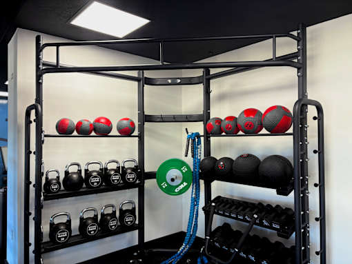 A rack of red and black kettlebells and weight plates in a gym. at Vivo Toledo Apartments, Ohio, 43607