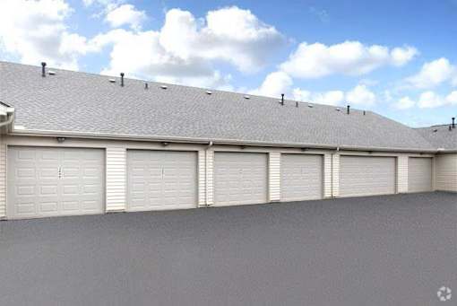 A row of white garage doors on a grey building.