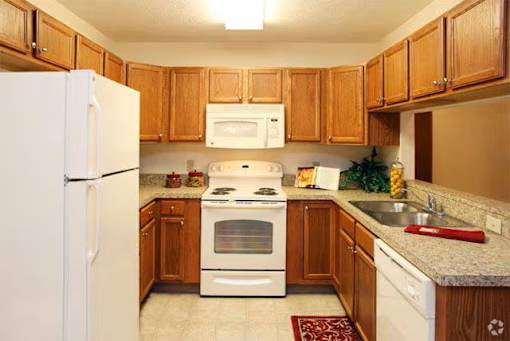 A kitchen with wooden cabinets and white appliances.