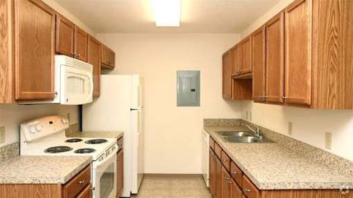 A kitchen with wooden cabinets and a white refrigerator.