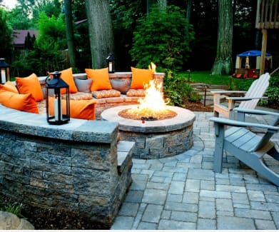a patio with a fire pit and seating area
