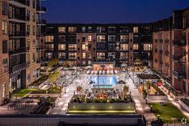 an aerial view of an apartment complex with a pool in the middle