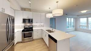 a white kitchen with a sink and a refrigerator