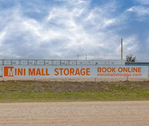 A billboard for Mini Mall Storage with the text "Book Online" and a website address.