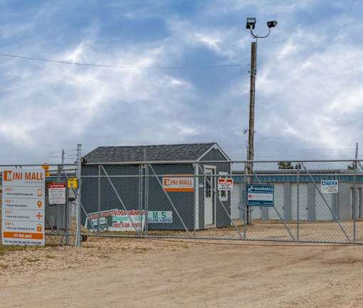 A construction site with a fence and a sign for a building materials store.
