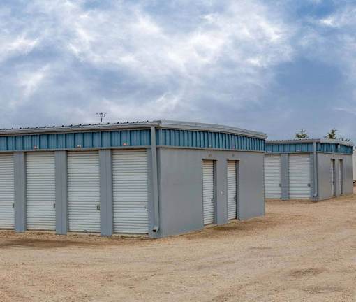 A series of storage units with closed grey doors are lined up in a row.