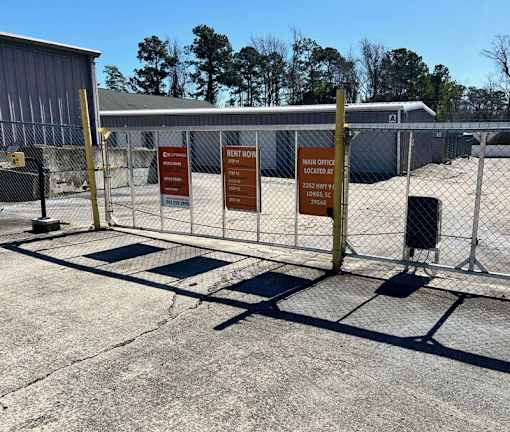 A fenced area with signs for renting and the main office.
