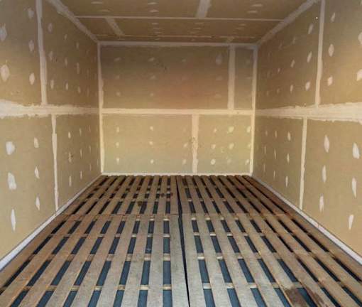 A room with wooden flooring and walls covered in insulation material.