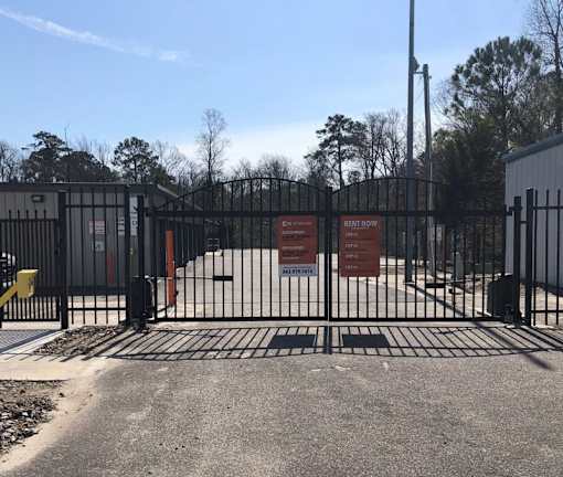 A gated entrance to a rental property with a sign that reads "Rent Now".