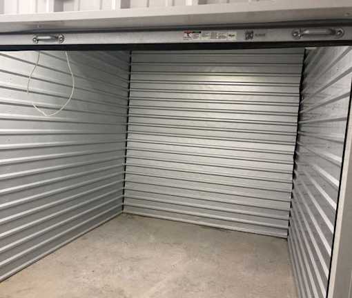 A storage unit with a closed grey shutter door.