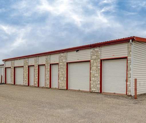 A long storage unit building with red and white trim.
