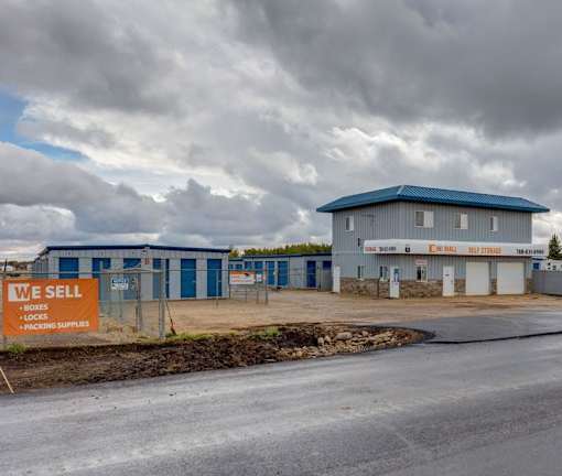 A sign in front of a building that says "We Sell Boxes, Locks, and Packing Supplies."
