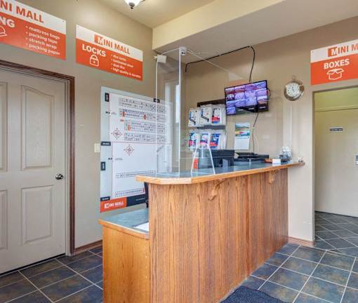 A reception area with a wooden desk and a sign that says "Mini Mall".