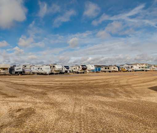 A field with a row of RVs parked in the distance.