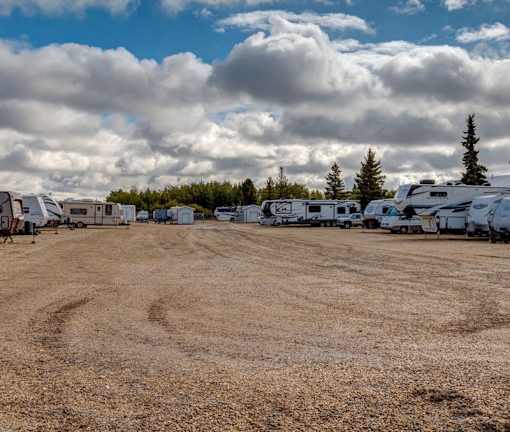 A field with a few RVs and trees in the background.