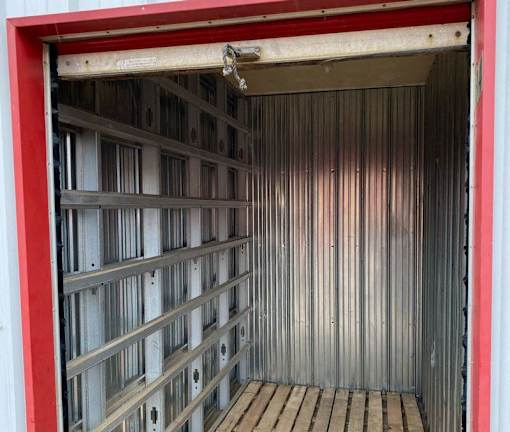 A red and white garage door is open.