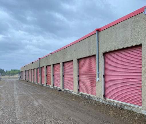 A long row of red garage doors on a concrete building.