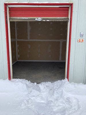 an open garage door with snow on the floor