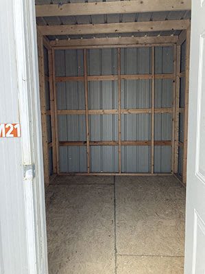 an empty room with shelving in a room with a door