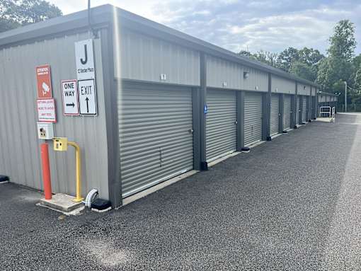 A long row of storage units with a one way exit sign.