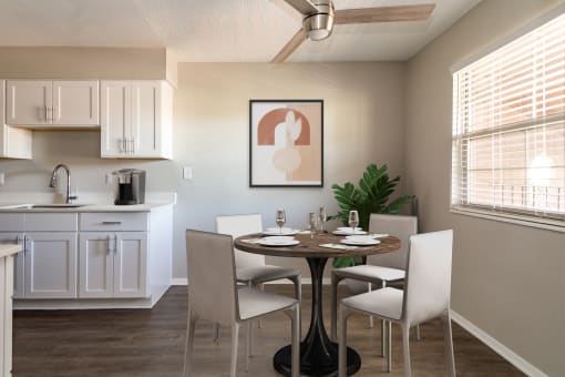 Renovated kitchen with white cabinetry, laminate countertop, and wood-style plank flooring  at Acacia Gardens, Albuquerque, New Mexico