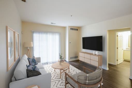 a living room with a couch and a table and a television at Highlands at Faxon Woods, Quincy, MA