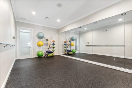 the living room has a workout room with weights and mirrors