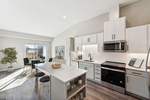 a kitchen with white cabinets and a white island with a white counter top at SoRoc on Maine in Rochester, MN
