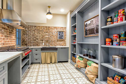 A kitchen with a brick wall and a tile floor.