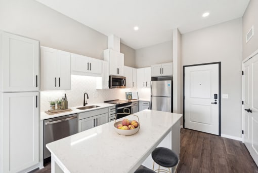 a kitchen with white cabinets and stainless steel appliances and a white counter top at SoRoc on Maine in Rochester, MN