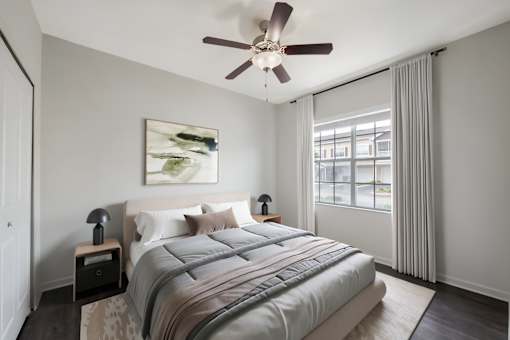 A bedroom with a large bed and a ceiling fan.