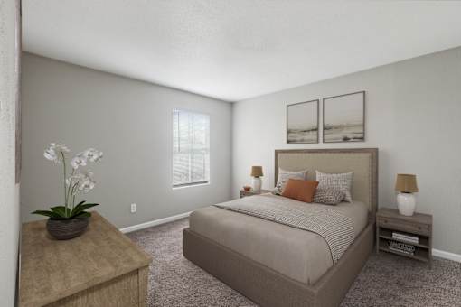A bedroom with a large bed, a nightstand, and a table with a vase of flowers.