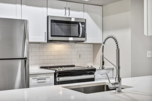 Renovated deluxe home featuring white cabinets and stainless steel appliances at The Lodge at Lakeline Village, Texas, 78613