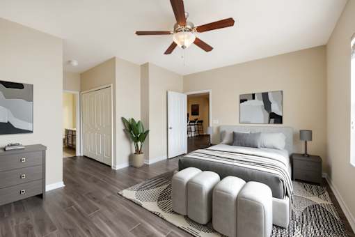 A bedroom with a large bed and a ceiling fan.