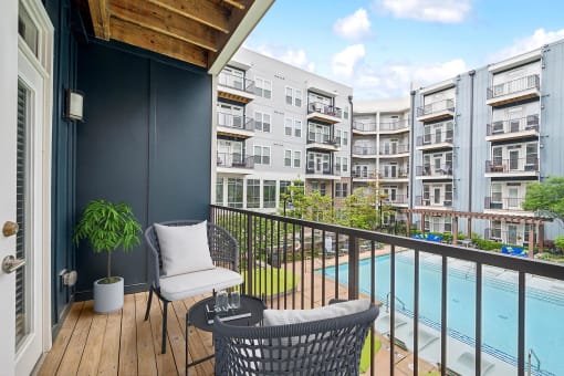 a balcony with chairs and a pool and an apartment building at Glenwood at Grant Park Apartments, Georgia