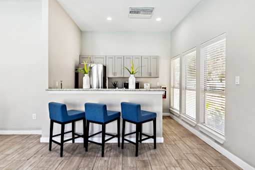 A Kitchen with a Bar Chairs at Flats on Chapel Apartments, Texas