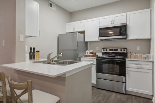 a kitchen with stainless steel appliances and white cabinets