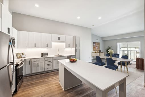 an open kitchen and dining room with white cabinets and a white table at SoRoc on Maine, Minnesota, 55904