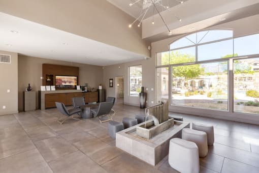 the living room of a clubhouse with a seating area and large windows at Altezza High Desert, Albuquerque, 87111