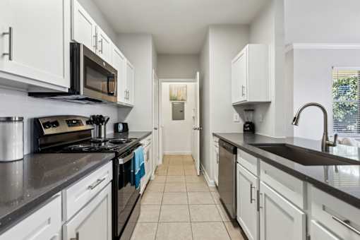 A Kitchen with Black Countertops at Flats on Chapel Apartments, Waco