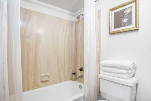 A bathroom with a wooden wall and a white towel rack.
