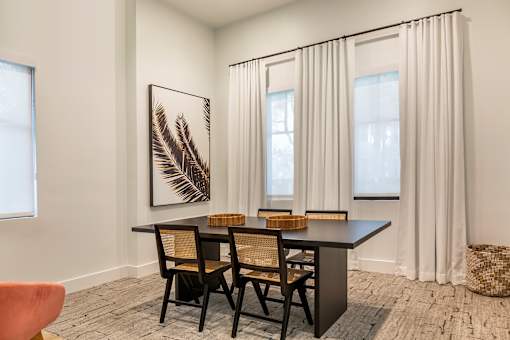A room with a black table and chairs at the clubhouse l at Floresta apartments in Jupiter, FL