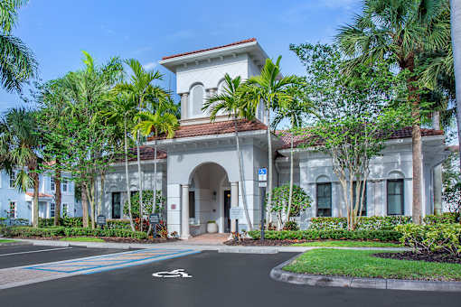 A white building with a blue sign in front of it.