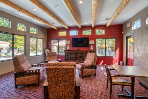 a living room with chairs and a table and a television at Vizcaya, Santa Fe, 87505