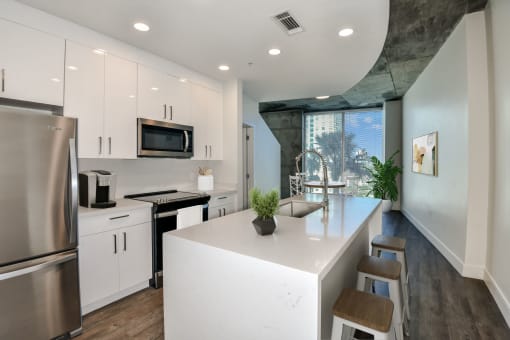 renovated home | kitchen with white cabinets, white quartz countertops, stainless steel appliances