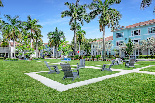 A park with benches and palm trees at Floresta apartments in Jupiter, FL