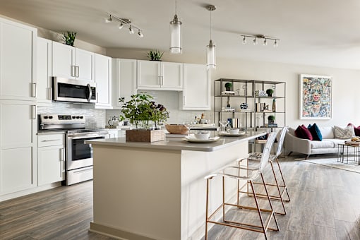 A modern kitchen with a white color scheme and a large island.