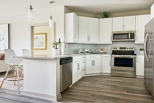 A modern kitchen with white cabinets and stainless steel appliances.
