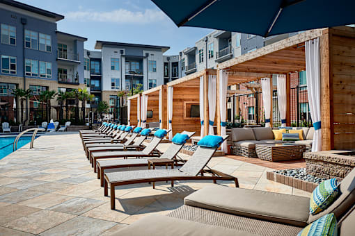 A row of sun loungers are arranged on a patio.